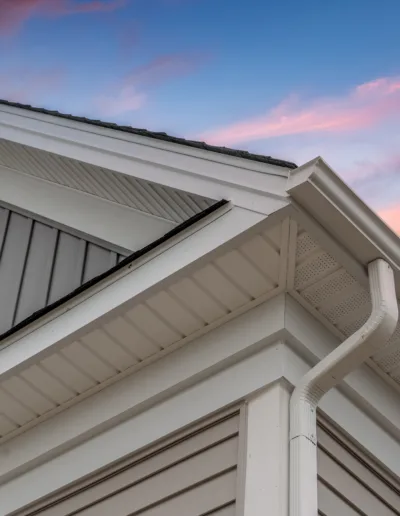 The roof of a house with a sunset behind it.