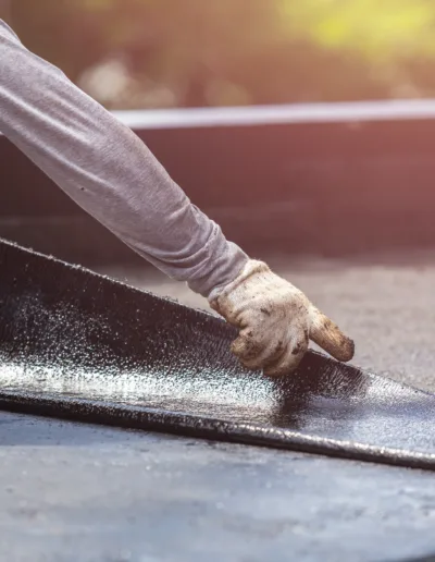 A man is installing a rubber roof on a roof.